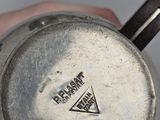 a close up of a silver coffee pot with a sticker on it