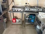 two stoves in the middle of a kitchen with pots and pans on them