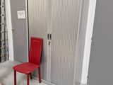une chaise rouge placée devant une porte métallique