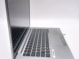 a silver laptop with a black keyboard on a white surface