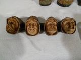 five ceramic heads of people sitting on a table