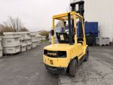 un chariot élévateur jaune garé devant un immeuble
