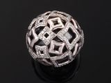 a white gold and diamond ball ring on a black surface