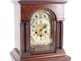 a wooden clock that is sitting on a white surface