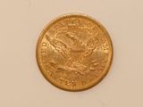 a close up of a gold coin on a white surface