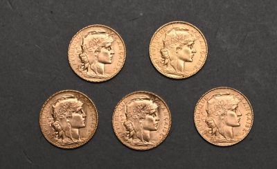 four gold sovereigns of different sizes and shapes on a black surface