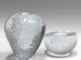 two glass vases sitting next to each other on a table