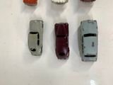 several toy cars are lined up in a row on a white surface
