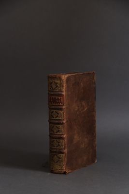 an old book sitting on top of a gray surface