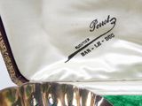 a silver plate with a bird on it sitting in a case