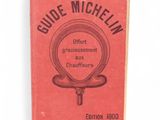an old book with a red cover and black writing on it