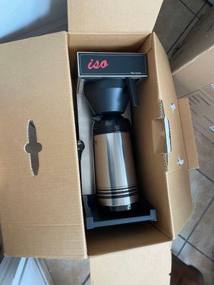 a coffee maker sitting inside of a box on the floor