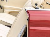 a red and white convertible car parked in a parking lot
