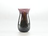 un vase violet posé sur une table, sur fond blanc