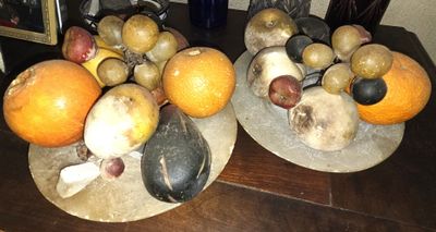 deux assiettes de fruits posées sur une table, avec un tableau accroché au mur