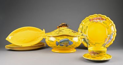 several pieces of yellow pottery are sitting on a gray surface