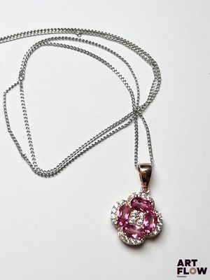 collier composé de pierres roses et blanches montées sur une chaîne, présenté sur un fond blanc