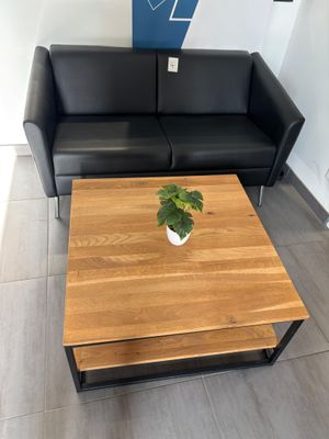 un canapé noir et une table en bois dans un salon