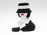 une figurine représentant une femme portant un chapeau et une écharpe