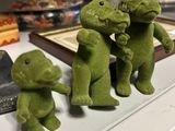 three green figurines of people standing on a table