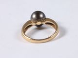a close up of a ring with a black pearl on it