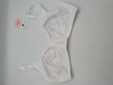 une bralette blanche posée sur une table blanche, à côté d'une étiquette