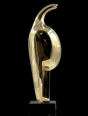 sculpture en or représentant un oiseau, posée sur un socle noir