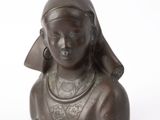 statue en bronze représentant une femme portant des boucles d'oreilles sur la tête