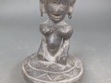 statue représentant une femme tenant un bébé dans un bol posé sur une table