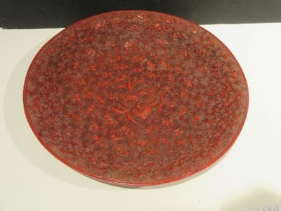 a red plate with a design on it on a white surface