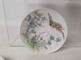 a plate with a picture of a bird and flowers on it