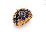 a close up of a gold ring with blue stones