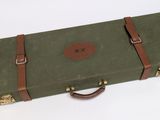 une valise verte avec une poignée marron sur un fond blanc