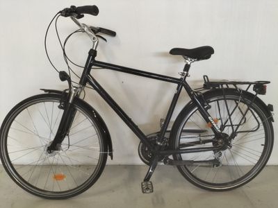 un vélo noir appuyé contre un mur blanc