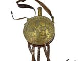 a small brass object with a tassel hanging from it ' s neck