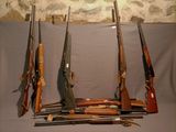 un grand nombre d'armes à feu posées sur une table