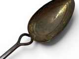 a spoon with a handle on a white surface