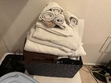 towels stacked on top of a basket in a bathroom next to a toilet