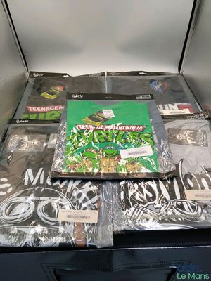 many t - shirts in a box on a table