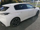 the rear end of a white car parked on the side of the road