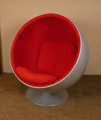 une chaise boule rouge et blanche posée dans une pièce