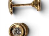 two pairs of gold and diamond stud earrings on a white surface