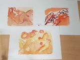 three paintings on the table one is orange and the other is red