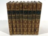 six vieux livres sont alignés sur une surface blanche