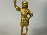 gold statue of a man holding a glass in his right hand