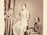 an old black and white photo of a woman sitting next to a man