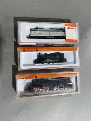 trois trains en boîte posés les uns à côté des autres sur une table