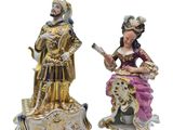 two figurines of a man and a woman sitting on a bench