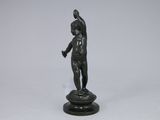 statue of a man holding a tennis racquet on top of a black base