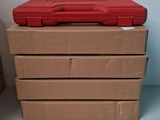 une boîte à outils rouge posée sur une pile de cartons marron